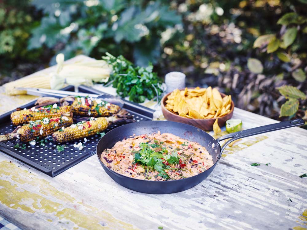 Black Steel BBQ grillplaat 44x32 cm op tafel met nacho's en een pan